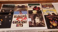 Twenty LP vinyl records laid out showing a variety of album covers from various artists including Barbra Streisand, Hank Williams and Alabama.
