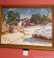 Full view of framed oil painting depicting a snow-covered ranch landscape with rocks and trees.