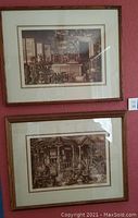 Two framed lithographs displayed on a wall, one above the other. Sepia-tone scenes of antiques. Wooden frames, double matted.