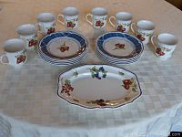 Full set of 8 mugs, 8 salad plates, and 11-inch serving platter displayed on table.