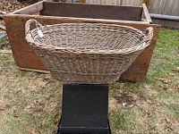 Exterior side view showing the oval shape, woven wicker texture, and one handle on the side of the basket.