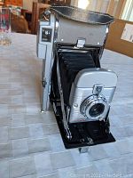 Side view of the Polaroid Model 80 showing the extended bellows and lens area.