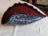 Side angle of amethyst seashell glass dish showing swirling grey cloud patterns and wavy edge