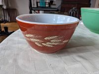 Front view of brown Pyrex mixing bowl with white wheat stalk designs.