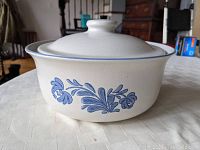 Front view photo of the white ceramic casserole dish showing blue floral design on the side and lid in place.
