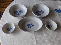 Full set of five Pfaltzgraff Yorktowne bowls arranged on table showing oval vegetable bowl and round bowls in different sizes.