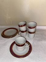 Set of 5 porcelain cups stacked and 4 saucers laid flat, showing 24K gold plating and burgundy banding