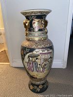 Full view of the Chinese porcelain floor vase showing painted traditional scene and gold lion head ring handles