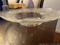 Side angle view of flamingo glass bowl showing scalloped edges and raised base.