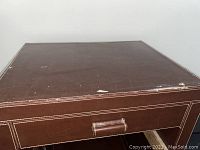 Top surface of wine rack showing wear, scratches and damage to faux leather covering