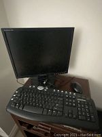 Samsung SyncMaster 710N computer monitor with Emachines wired keyboard and mouse on a wooden surface