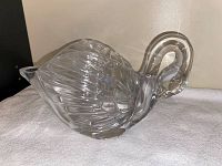Front and side view of the clear glass swan figurine showing detailed feather etching and smooth finish.