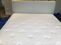 Front view of white upholstered headboard with mattress