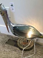 Side and front view of the pelican metal lamp showing entire bird figure and base