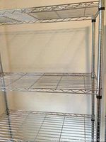 Front view of three shelves showing wire grid construction and chrome finish.