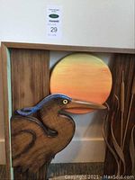 Front view of the framed wooden artwork with the heron and sunset