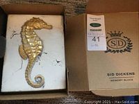 Opened shipping box showing memory block with gold seahorse and original packaging.