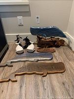 Overview of all items including wooden whales on floor and driftwood mounted whales, ceramic figurines