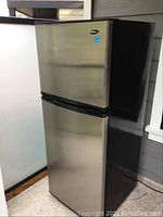 Front view of refrigerator freezer showing stainless steel doors and black side panels