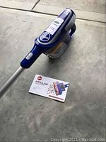 Full view of assembled vacuum and user manual on floor