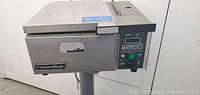 Front and side view of stainless steel commercial food steamer/warmer labeled RoundUp with control panel.