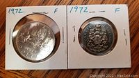 Obverse and reverse of 1972 Canadian one dollar and fifty cent coins in individual holders.