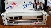 Photo of boxed Sawyer Brown Super Friction-Powered Bus Bank showing the toy bus inside original packaging with band photo and branding.