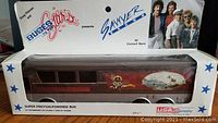 Photo of the friction-powered toy bus in original packaging showing band photo and branding on the box