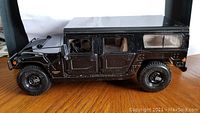 Side view of black Hummer diecast model showing four doors and detailed tires.