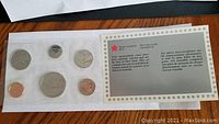 Photo showing entire uncirculated coin set in sealed plastic packaging, including six visible coins and an insert from the Royal Canadian Mint describing the set.