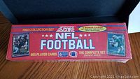 Front side of the unopened 1990 Score NFL Football complete set box showing 665 player cards, featuring the product branding and images of football players.