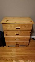 Front view of handmade pine dresser showing four drawers with wooden handles.