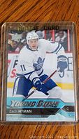 Front side of a 2016-17 Upper Deck Young Guns Zach Hyman rookie hockey card showing player in action in Toronto Maple Leafs uniform.