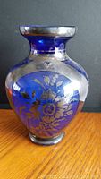 Front view of cobalt blue glass vase with silver floral pattern tarnished on upper neck and body.
