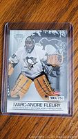 Front side of Marc-Andre Fleury rookie card showing player in action with Penguins logo and numbering 593/750.