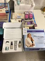 Full lot overview showing the Dr. Denese skin resurfacing system box, Algenist skin care set open with products, assorted smaller skin care items including Lava de Provence and personal care items.