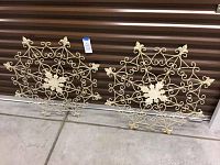 Pair of matching ornate metal wall decor pieces with scrollwork and floral design, distressed cream paint finish.