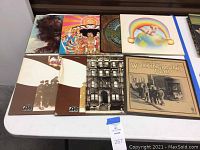 Overview of all eight vinyl records laid on table showing album sleeves