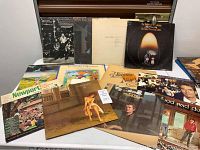 Photo showing a collection of vintage vinyl records on a table including identified artists and album covers.