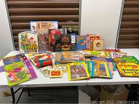 Front view showing a variety of children's books laid out on a table with colorful covers and assorted titles.