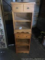 Front view of two stacked wooden side tables with two drawers and two shelves, showing scratches and wear.