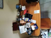 Multiple small jewelry boxes and loose jewelry displayed on wooden table