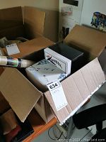 Top view of open box showing boxed tea set and other packages in cardboard box.