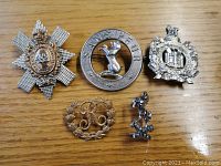 Photo showing all five military badges in a grouping with wooden background.