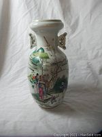 Porcelain vase with hand-painted traditional Chinese figures and two ornamental handles shown in full view.