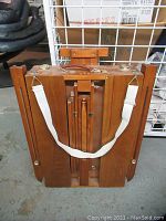 Front view of easel folded flat showing white strap and top handle