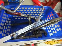 Blue plastic basket containing all tools including hand drill, pipe wrench, T-bevel and drill chuck