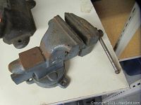 Front and side view of the 3.5 inch bench vice showing the rusted metal jaws and rotating base.