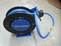 Front view of blue Mastercraft air hose reel with attached blue air hose coiled on the reel.