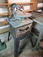 Front view of scroll saw mounted on metal stand